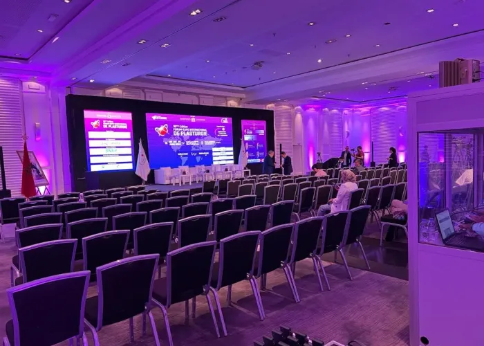 Salle de conférence équipée par AV SYSTEM, comprenant écran de projection et système audio, idéale pour des événements professionnels et des formations interactives.