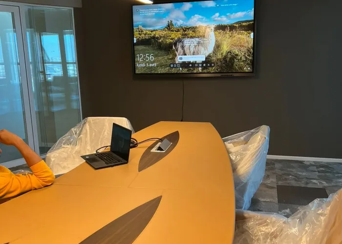 Salle de réunion équipée par AV SYSTEM en solutions audiovisuelles : écran interactif, microphones, caméras de visioconférence et système de sonorisation.