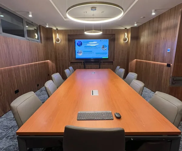 Salle de réunion spacieuse équipée par AV SYSTEM, avec écran interactif et technologie audiovisuelle pour des réunions et formations efficaces.