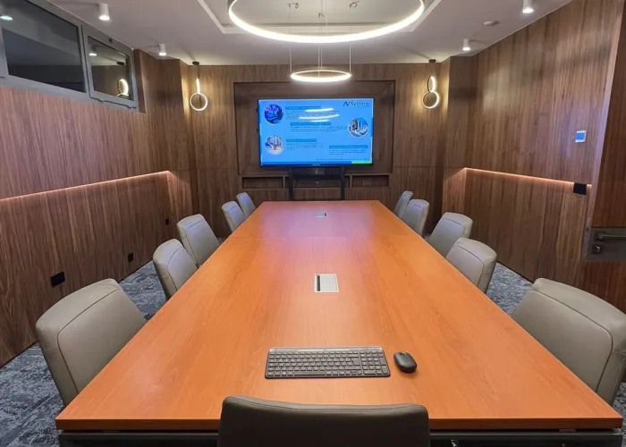 Salle de réunion spacieuse équipée par AV SYSTEM, avec écran interactif et technologie audiovisuelle pour des réunions et formations efficaces.