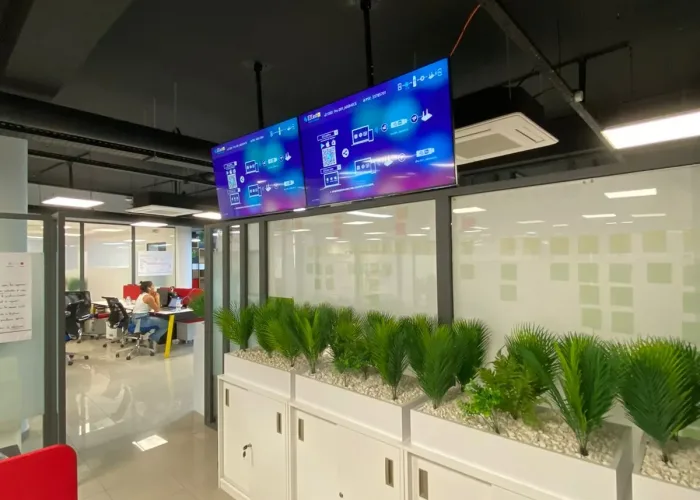 Espace de travail moderne avec équipement audiovisuel d'AV SYSTEM, incluant un système de visioconférence, des écrans HD et un mobilier ergonomique.