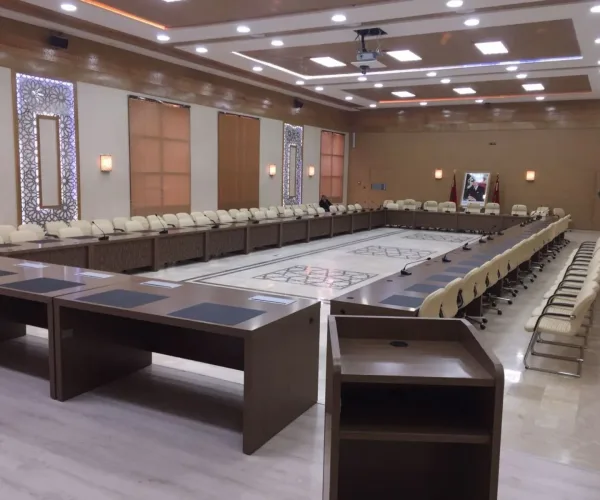 Grande salle de réunion équipée par AV SYSTEM, avec écrans interactifs, microphones et système audio pour des conférences et présentations efficaces.