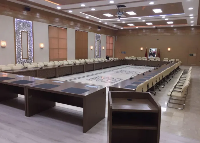 Grande salle de réunion équipée par AV SYSTEM, avec écrans interactifs, microphones et système audio pour des conférences et présentations efficaces.
